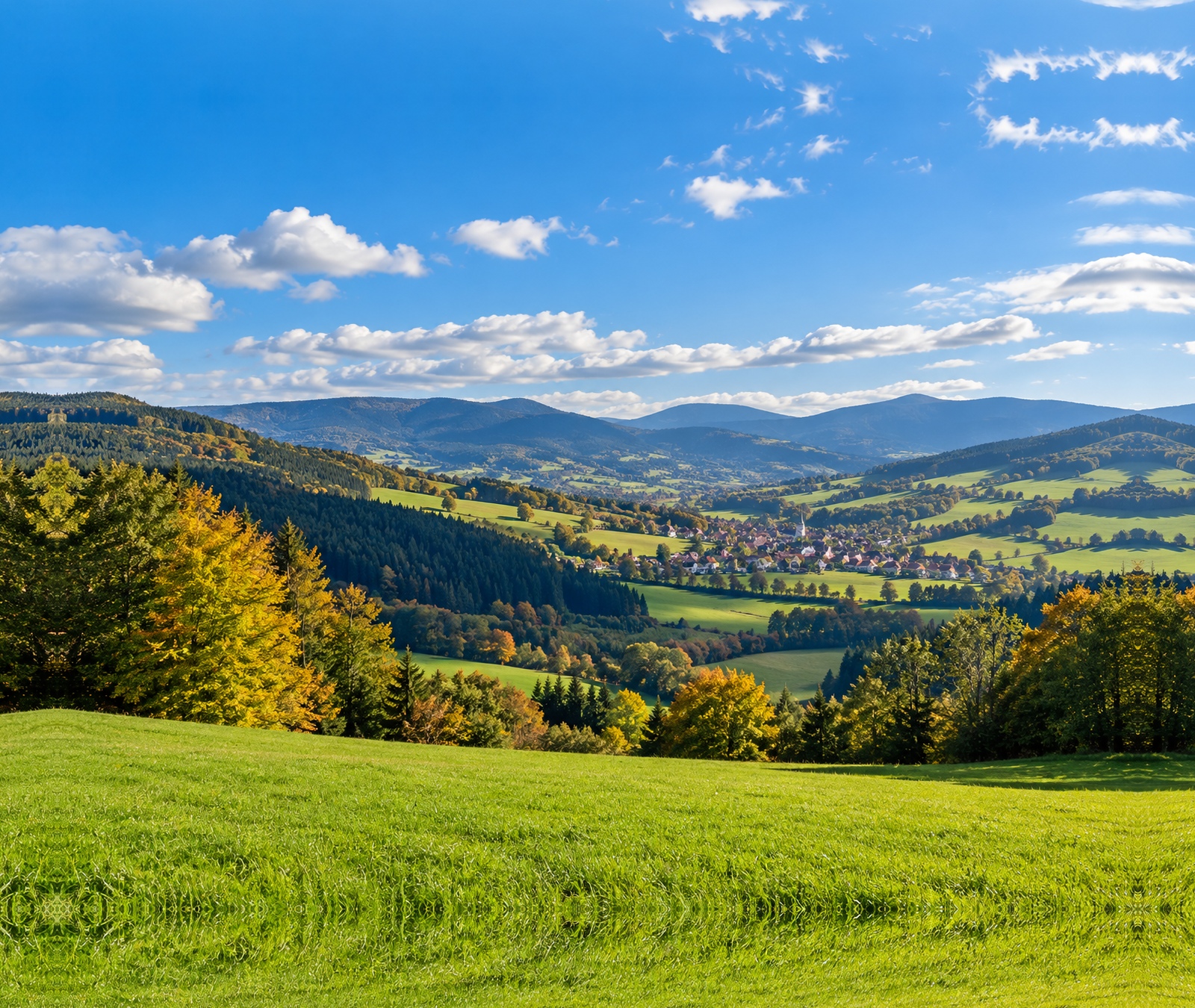 Paysage français de fin septembre avec collines verdoyantes, premiers tons d’automne et éclaircies entre les nuages