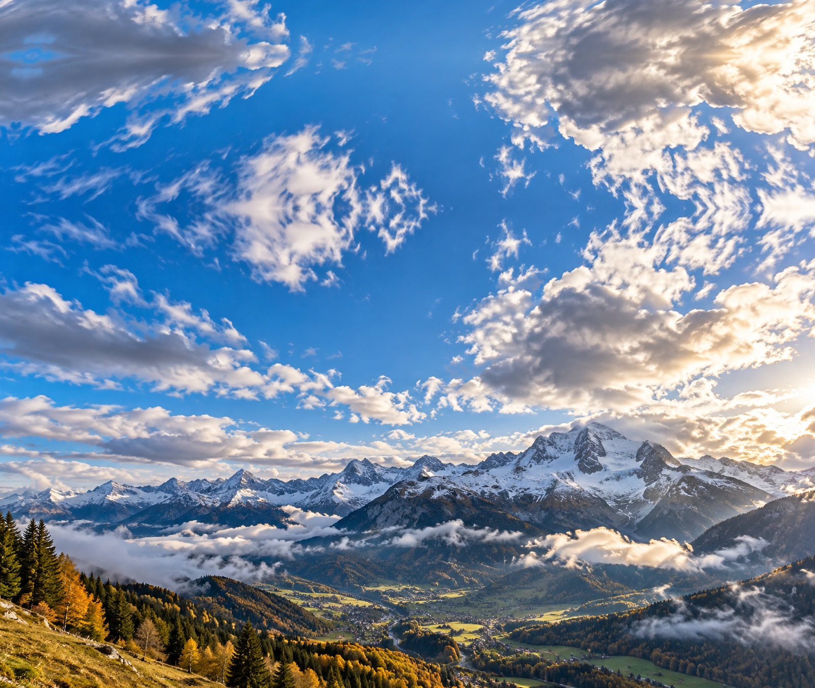 Massif alpin français en automne avec neige sur les hauts sommets, éclaircies et nuages bas, image symbolique du temps frais et changeant.